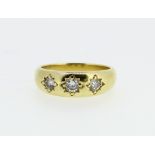 18ct yellow gold three stone gypsy ring set with three brilliant cut diamonds, stamped 750, size