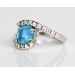 18ct white gold twist ring, the central oval cut blue topaz in claw setting, on diamond set twist
