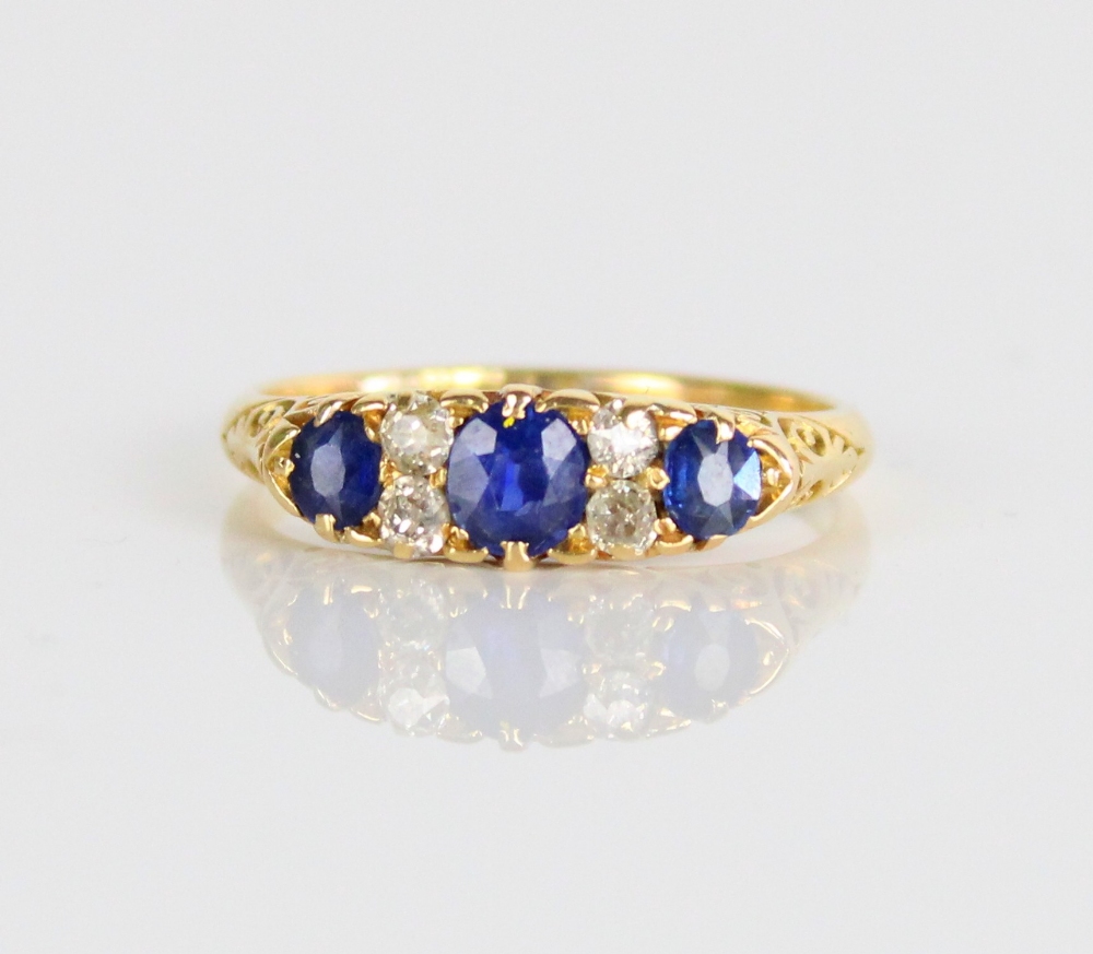 18ct yellow gold sapphire and diamond ring, the three graduated round cut sapphires separated by