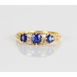 18ct yellow gold sapphire and diamond ring, the three graduated round cut sapphires separated by