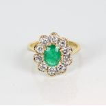 18ct yellow gold emerald and diamond cluster ring, the central oval cut emerald surrounded by a halo