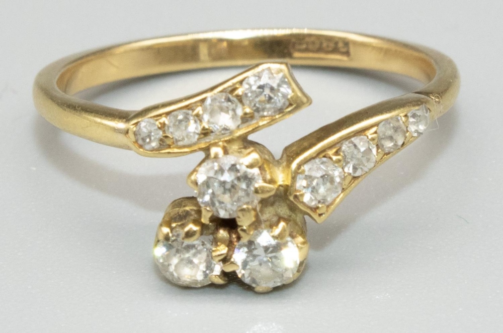 18ct yellow gold diamond twist ring, the cluster of three round cut diamonds in claw settings, on