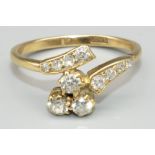 18ct yellow gold diamond twist ring, the cluster of three round cut diamonds in claw settings, on