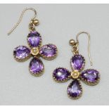 Yellow metal floral drop earrings set with pear cut amethysts and seed pearls in the form of