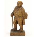 C20th softwood carved model of a stout Gentleman, standing with hat and walking cane, on square