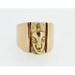 Yellow metal ring with tribal mask decoration, on plain band, size T, 22.8g
