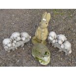 Four reconstituted stone garden ornaments, a rabbit, puppies and a hedgehog