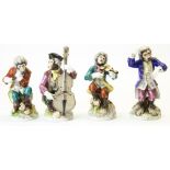 Set of four continental porcelain Meissen style monkey bandsmen, decorated in colours, on circular