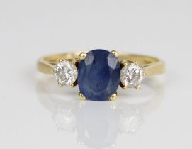 18ct yellow gold sapphire and diamond ring, the central oval cut sapphire flanked on either side
