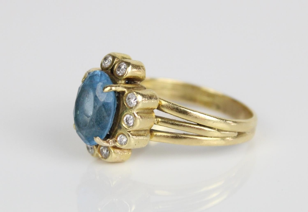 18ct yellow gold cluster ring, the central oval cut blue stone surrounded by brilliant cut diamonds, - Image 2 of 3