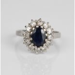 18ct white gold diamond and sapphire cluster ring, the central oval cut sapphire surrounded by a
