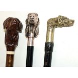 Ebonised walking stick with cast Hounds head handle, another similar and a stick with carved