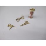 Three 9ct yellow gold charms including a pair of scissors, handcuffs and a ballerina, all stamped