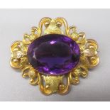 9ct yellow gold brooch set with large central oval cut amethyst, the border decorated with foliage