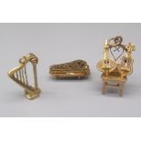 Three 9ct yellow gold charms including harp, chair with guitars and harpsichord, all stamped 375,