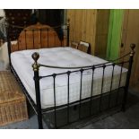 Victorian style double bed, black metal head and footboards with dished brass top rails and finials,