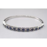 18ct white gold bangle with open box clasp, set with diamonds and sapphires, stamped 750, 11.8g