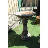 Reconstituted stone bird bath with floral and leaf design to plinth and fleur-de-lys design to top