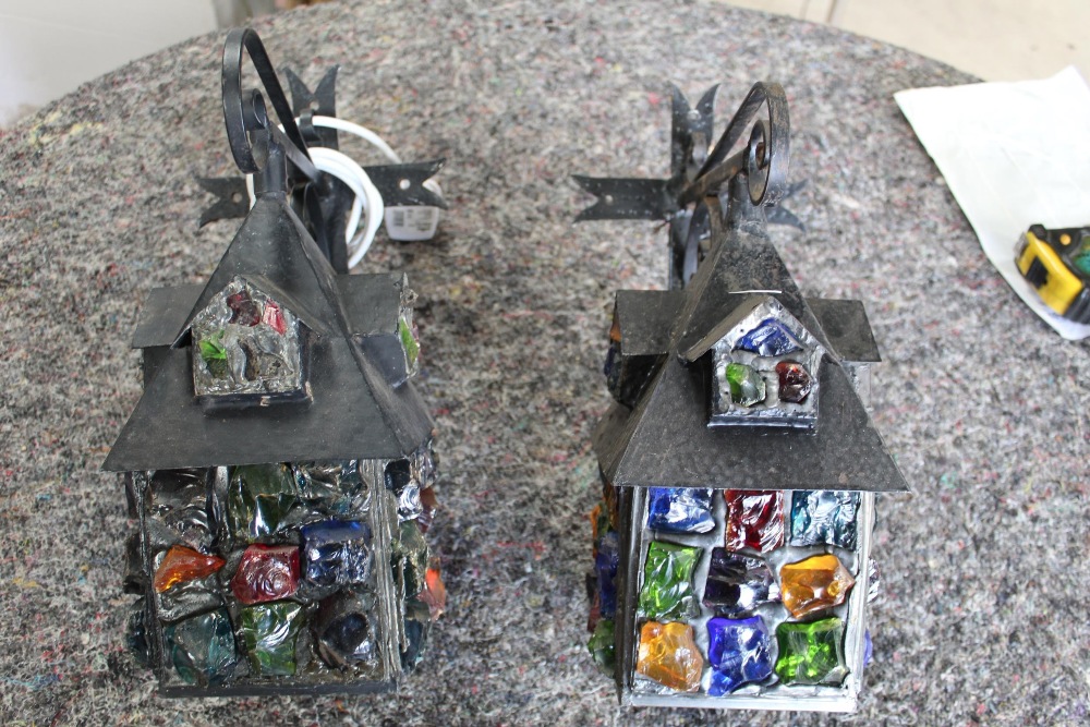 Pair of well made outdoor electric lanterns in the shape of a house, decorated with coloured