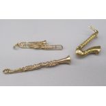 9ct yellow gold clarinet charm, a 9ct yellow gold saxophone brooch, both stamped 375, 5.8g, and a