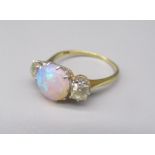 18ct yellow gold ring, the central opal effect stone flanked on either side by a brilliant cut