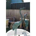 pair of well cast metal cranes painted with a bronzed effect green H100cm