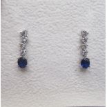 18ct white gold diamond and sapphire drop earrings, each set with four brilliant cut diamonds and an