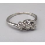 Platinum three stone diamond ring, the brilliant cut illusion set diamonds on twist mount, stamped