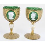 Pair of late C19th Bohemian small green and gilt wine glasses, front panels decorated in white