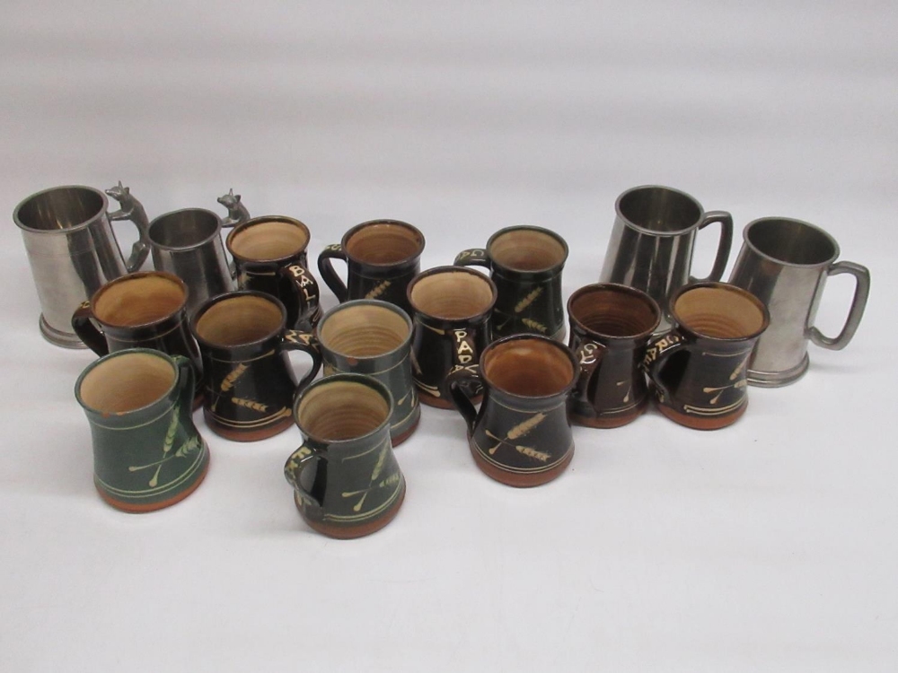 12 studio pottery mugs, with words to handle and 4 pewter tankards, 2 in relation to the