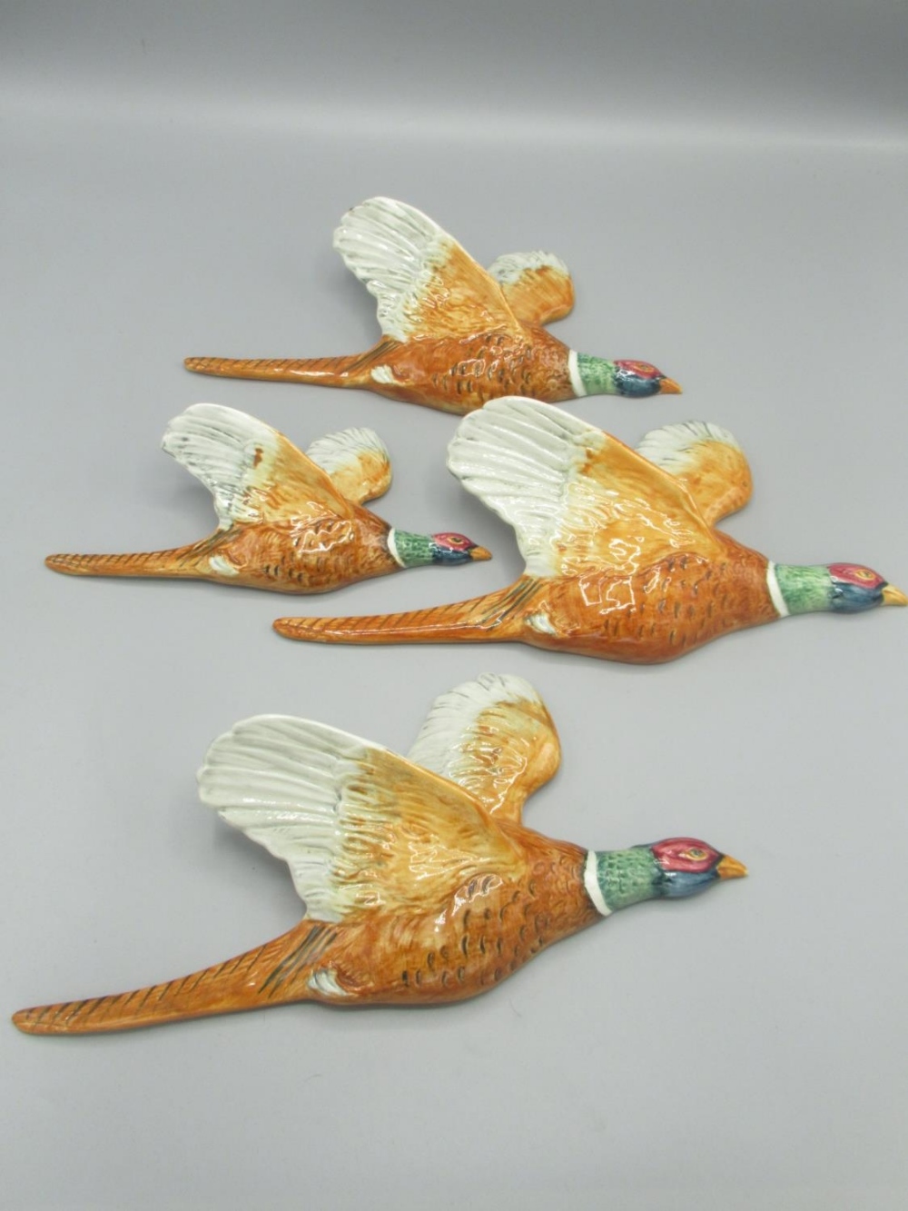 Four Beswick graduated flying Pheasants wall plaques