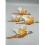 Four Beswick graduated flying Pheasants wall plaques