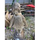 Reconstituted stone statue of a young girl leaning against a tree stump