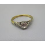 18ct yellow gold solitaire ring, the round cut diamond set in platinum mount with diamond set