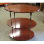 C20th etagere, three oval mahogany tiers with brass gallery, supports and finials, later casters,