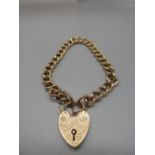 9ct yellow gold chain link bracelet with engraved heart padlock clasp and safety chain, stamped 9ct,