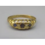 18ct yellow gold gypsy ring set with blue and clear stones, stamped 18, size Q, 2.6g