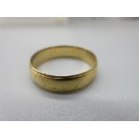 18ct yellow gold wedding band with worn design, size R, stamped 18, 3.4g