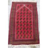 Afghan red ground wool prayer rug, stepped field with geometric medallions, in repeating stylized