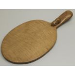 Robert Mouseman Thompson of Kilburn - an oak oval cheese board, curved handle carved with