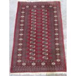 Bokhara pattern red ground wool rug, field with octagonal medallions, in hooked stylized