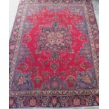 Large Persian pattern multicoloured wool rug, red field with central floral medallion and blue