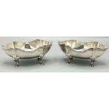 Pair of George V hallmarked silver oval dishes with reeded rims on four paw feet, by A Zimmerman