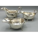 George V hallmarked silver sauce boat, with shaped rim and scroll handle on three shell cast feet,