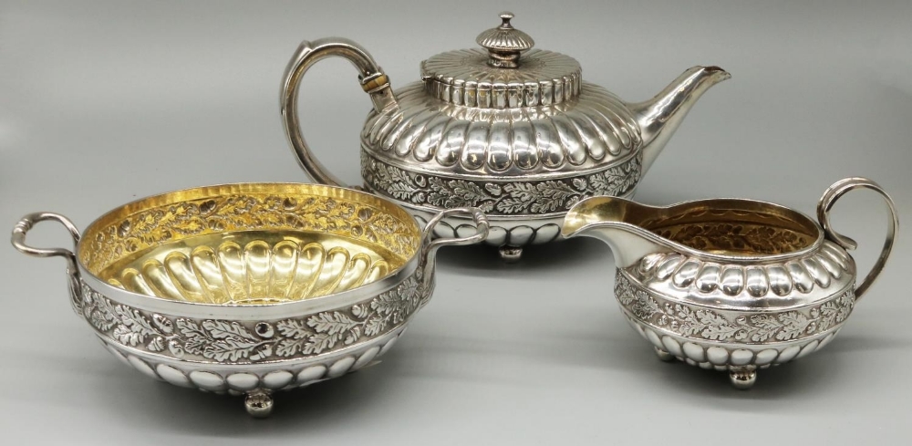 George IV hallmarked silver three piece tea service, compressed lobed circular bodies with an oak