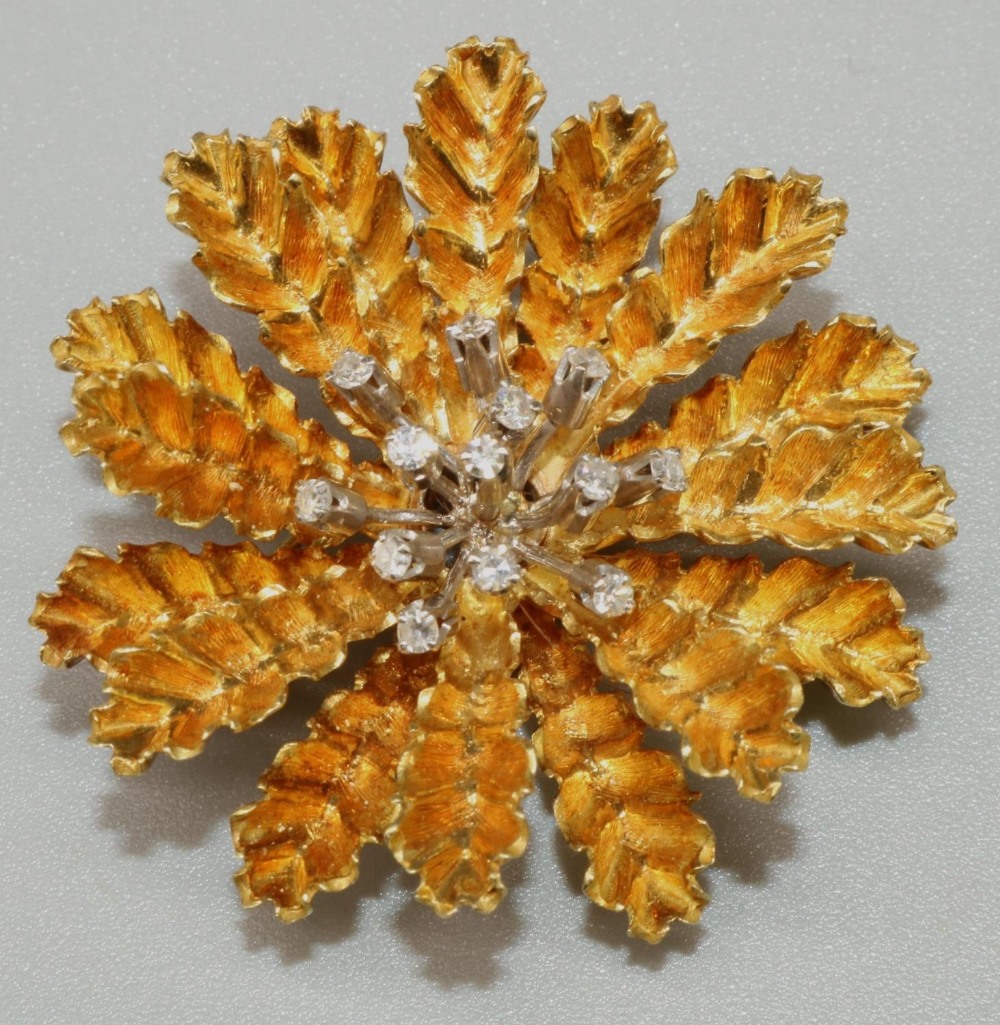 Mid C20th 18ct yellow gold brooch in the form of a stylised flower head, around a centre of thirteen