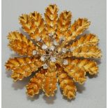 Mid C20th 18ct yellow gold brooch in the form of a stylised flower head, around a centre of thirteen