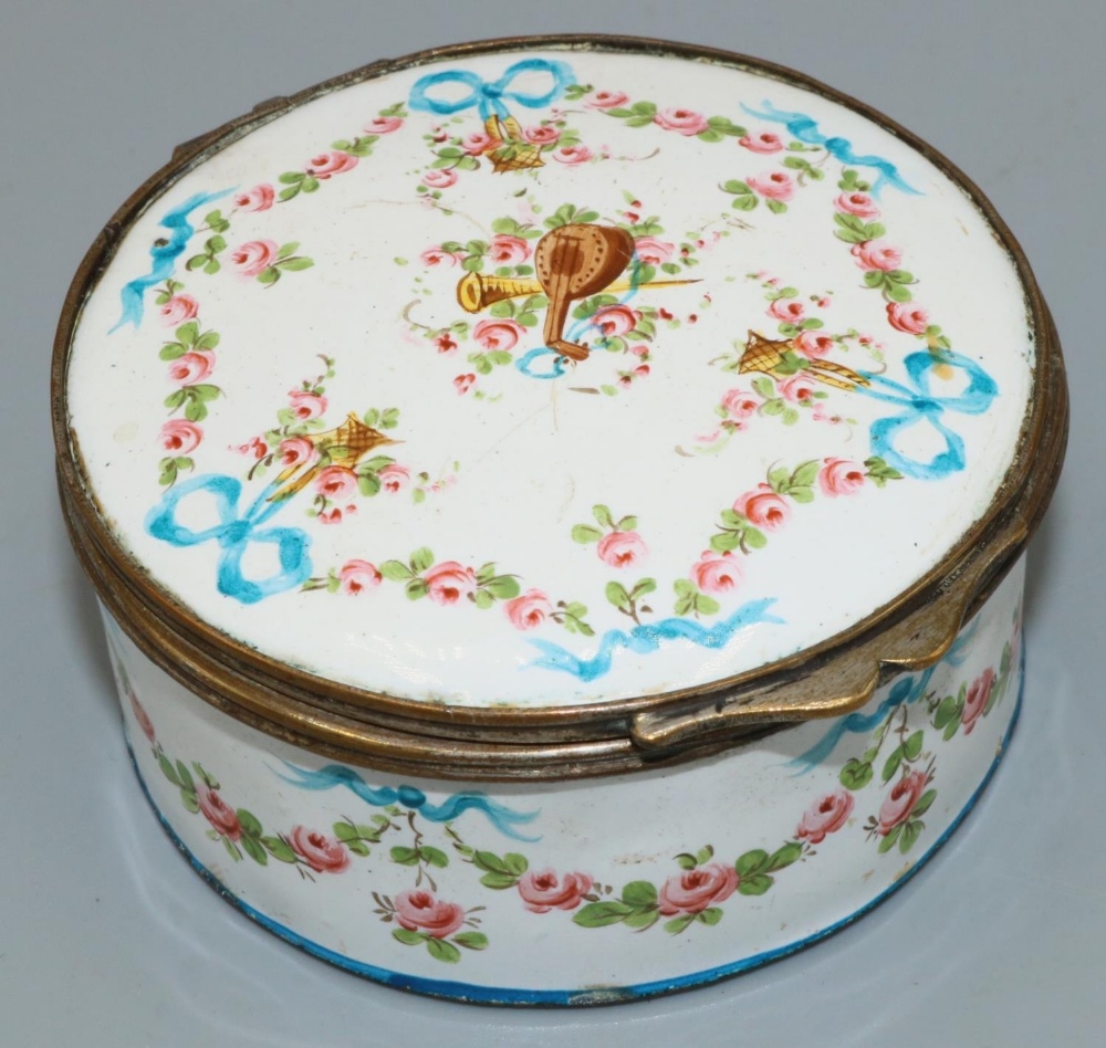 C19th gilt metal mounted white enamel circular box, painted with musical trophies in ribbon tied