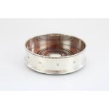 ER.II hallmarked silver wine coaster with beaded edge and stepped foot, turned wooden base with