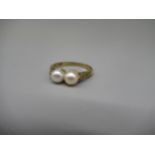 9ct yellow metal ring set with two pearls on diamond set shoulders, stamped 9ct, size N, 2.5g